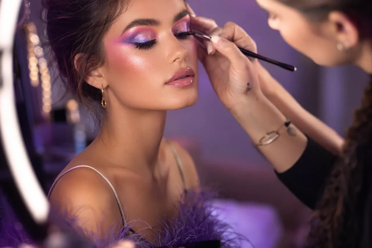 Makeup artist working on a model under studio lighting